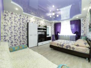 a bedroom with purple walls and purple curtains at Apartment Grand Kazan on Chistopolskoi 79 in Kazan