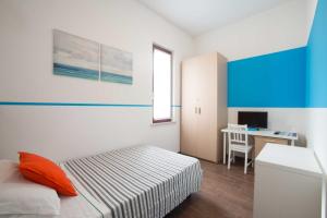 1 dormitorio con 1 cama y escritorio con ordenador en Blue Hotel, en Suzzara