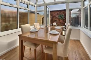 a dining room with a table and chairs and windows at 52 Minster in Beverley
