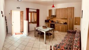uma cozinha com uma mesa e um sofá num quarto em B&B Serena em Longi