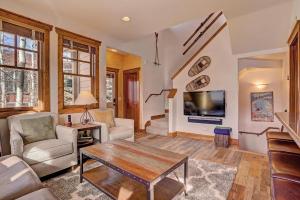 uma sala de estar com uma mesa e uma televisão em Mountain Ridge Chalet em Breckenridge