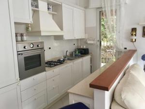 uma cozinha com armários brancos e um forno com placa de fogão em Il Nido tra gli Ulivi em Rapallo