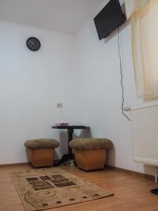una stanza con due sgabelli e un tavolo con televisore di Tornácos Vendégház a Vlăhiţa