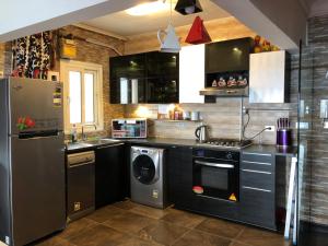 a kitchen with a refrigerator and a washer and dryer at Blue Bay Beach-Families only in Alexandria