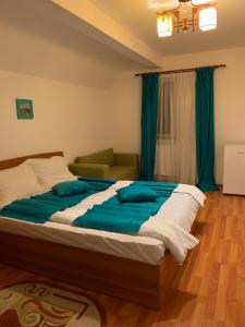 a bedroom with a large bed with blue pillows at Casa Galbena in Slănic