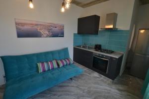 a living room with a blue couch in a kitchen at The Penthouse Flat-terrace&view in Senglea