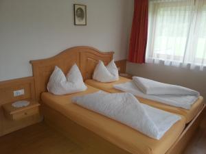 2 łóżka z białymi poduszkami w sypialni w obiekcie Apparthotel Stoanerhof w mieście Uderns