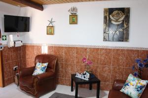 ein Wohnzimmer mit 2 Stühlen und einem Tisch in der Unterkunft Casa do Facho in Vila Chã