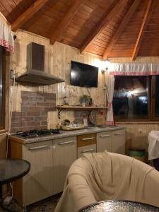 a kitchen with a stove and a tv on the wall at Casa Galbena in Slănic