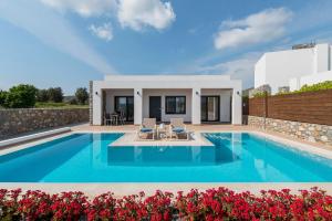 a villa with a swimming pool and a house at Prasonisi Villas in Kattavía