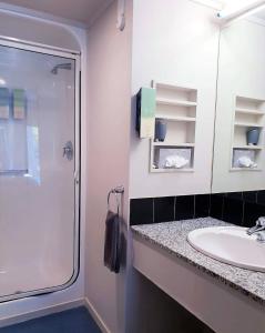 a bathroom with a glass shower and a sink at Parklane Motor Lodge in Auckland