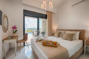 a bedroom with a bed with a table and a desk at Prasonisi Villas in Kattavía