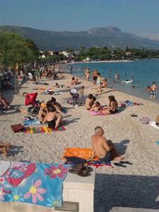 a group of people sitting on a beach at Vita Style in Kaštela