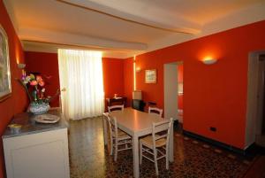 a dining room with orange walls and a table and chairs at LA CASA DI NONNO GINO in Levanto +13 photos