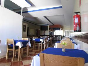 a restaurant with blue and white tables and chairs at Residêncial Carlos Carvalho in Praia
