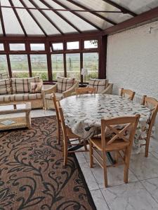 un patio con mesa, sillas y sofá en The Greannan Lower Self catering apartment en Blackwaterfoot