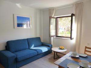 a living room with a blue couch and a table at Apartmani Lavanda in Vrsi
