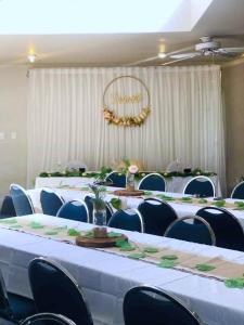 a group of tables and chairs in a room at Parklane Motor Lodge in Auckland +22 photos