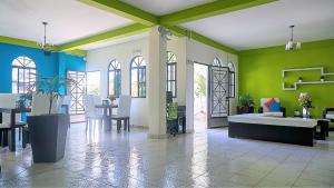 uma sala de estar com paredes verdes e brancas e uma mesa em Villa del Angel Hotel em San Salvador