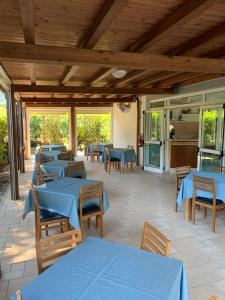un restaurant avec des tables bleues et des plafonds en bois dans l'établissement Hotel Mare Azzurro, à Terracine