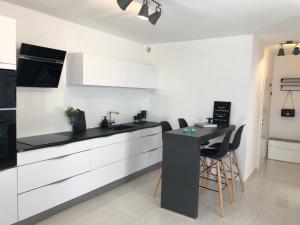 a kitchen with white cabinets and a black counter top at EllaVis Apartments in Vis