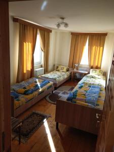 a living room with two beds and two windows at Lary Hostel in Suceava