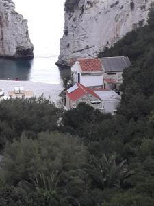 a house on the side of a mountain next to the water at Holiday home Stiniva in Vis