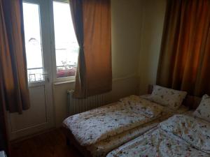 a small bedroom with two beds and a window at Lary Hostel in Suceava