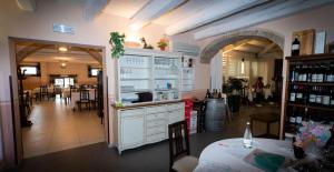 a kitchen with white cabinets and a dining room with a table at Hotel Ristorante Cantina Langelina in Corinaldo