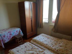 a bedroom with two beds and a dresser and a window at Lary Hostel in Suceava