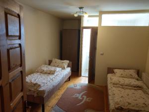 a small bedroom with two beds and a window at Lary Hostel in Suceava