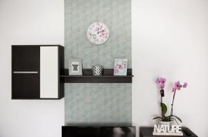 a room with a clock on the wall and a shelf at Apartament Anita in Vulcan +17 photos