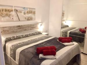 Pokój z 2 łóżkami z czerwonymi poduszkami w obiekcie Los Barqueros "Maria" Corralejo "Beach front - Town centre" w Corralejo +37 zdjęć