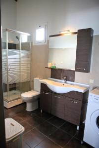ein Bad mit einem Waschbecken, einem WC und einer Dusche in der Unterkunft Havana 1 Sea and Pool Apartment in Ammoudara