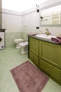 W łazience znajduje się zielona umywalka i toaleta. w obiekcie la casa di Susanna w mieście Rossiglione