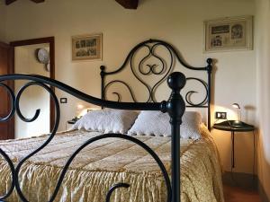 - une chambre avec un lit noir et blanc et des oreillers blancs dans l'établissement Agriturismo La Palazzina, à Palaia