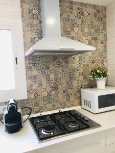 a kitchen with a stove top oven next to a microwave at Heart of Gracia in Barcelona