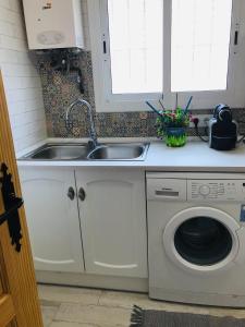 a kitchen with a sink and a washing machine at Heart of Gracia in Barcelona