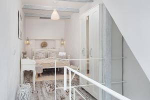 a white room with a bed and a staircase at CASA DO PESCADOR by Ammonite&Co in Olhão +30 photos
