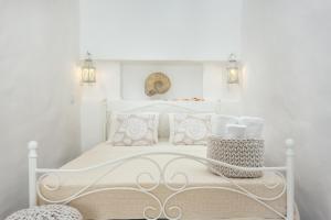 a white bedroom with a white bed with pillows at CASA DO PESCADOR by Ammonite&Co in Olhão