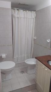 a white bathroom with a toilet and a sink at Hotel Lihuel in Villa Carlos Paz