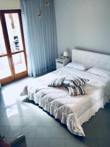 a bedroom with a large white bed and a window at Camere Mazara in Mazara del Vallo