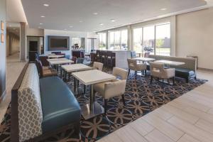 a restaurant with tables and chairs on a rug at La Quinta by Wyndham Terre Haute in Terre Haute