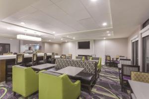 a dining room with tables and chairs and a tv at La Quinta by Wyndham Columbus North in Columbus