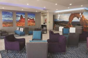a waiting room with chairs and paintings on the wall at La Quinta by Wyndham Kanab in Kanab