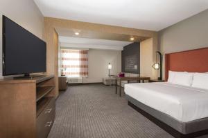 a hotel room with a bed and a flat screen tv at La Quinta by Wyndham South Jordan in South Jordan