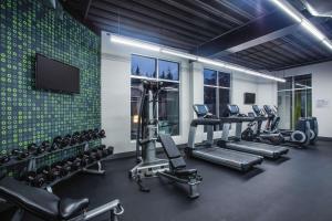 a gym with several tread machines and a flat screen tv at La Quinta by Wyndham Winchester in Winchester