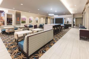 a restaurant with tables and chairs and a bar at La Quinta by Wyndham Terre Haute in Terre Haute