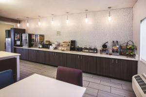 a restaurant with a kitchen with a counter top at La Quinta Inn by Wyndham Indianapolis North at Pyramids in Indianapolis