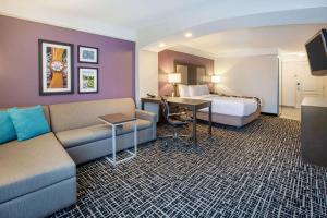 a hotel room with a bed and a couch at La Quinta by Wyndham Cincinnati Airport Florence in Florence